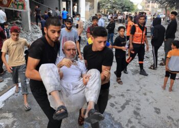 ORANG ramai membantu seorang lelaki warga emas yang tidak mampu berjalan selepas Israel melancarkan serangan udara di selatan Semenanjung Gaza. - AFP