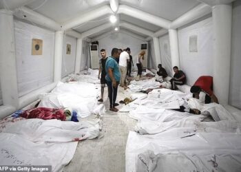 Penduduk Palestin mencari  ahli keluarga mereka dalam timbunan mayat di Hospital Gaza, semalam. – AFP
