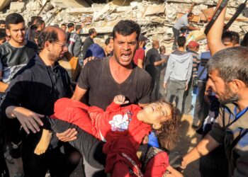 SEORANG lelaki mengangkat mayat kanak-kanak perempuan dari celah runtuhan bangunan selepas dibedil serangan udara Israel di Rafah, Semenanjung Gaza. - AFP