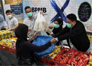 KAKITANGAN Bank Pembangunan Malaysia Berhad mengagihkan sumbangan makanan kepada golongan memerlukan.