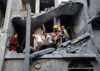 ANGGOTA keselamatan membawa turun orang awam dari blok penempatan yang musnah dibedil tentera Israel di Khan Yunis, selatan Semenanjung Gaza, Palestin. - AFP