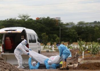 PETUGAS kesihatan lengkap dengan sut peralatan perlindungan diri (PPE) menguruskan jenazah korban akibat Covid-19 di Tanah Perkuburan Islam Seksyen 21, Shah Alam, Selangor pada Februari 2022. - MINGGUAN/ZULFADHLI ZAKI
