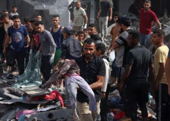 PENDUDUK Palestin memindahkan mayat dari runtuhan bangunan yang terkena bedilan bom Israel di Rafah di selatan Semenanjung Gaza.-AFP