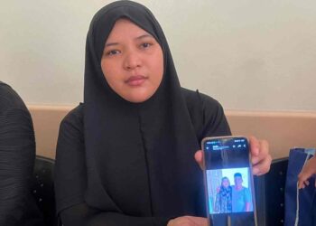 SITI Alora Fatihah Mohd. Aziz 
menunjukkan gambar kenangan bapa dan ibunya ketika ditemui Hospital Gua Musang, Kelantan hari ini.UTUSAN/AIMUNI TUAN LAH