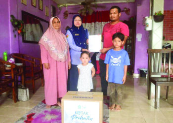 FARIHAH Che Husin (dua dari kiri) menyerahkan faedah pengurusan jenazah kepada Mohd. Syawal Arifin@Abd. Rahman ketika kunjungan Skuad Perkeso Prihatin ke rumah ibu mentua lelaki tersebut di Taman Perumahan Alor Jambu, Kuala Nerus semalam.