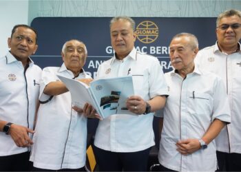 FD Iskandar Mohamed Mansor (tengah) melihat buku laporan kewangan Glomac selepas Mesyuarat Agung Tahunan Ke-39 di Menara Glomac, Kuala Lumpur, semalam. – UTUSAN/SHIDDIEQIIN ZON