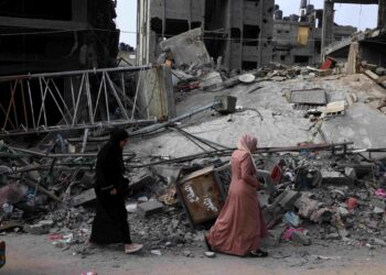 Dua wanita berjalan di tepi bangunan yang musnah diserang rejim zionis di Rafah dekat selatan Semenanjung Gaza, semalam. – AFP