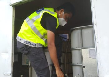 SEORANG anggota penguatkuasa KPDN Pulau Pinang memeriksa beberapa tangki yang dipercayai memuatkan minyak diesel bersubsidi dalam dua serbuan berbeza di Juru dan Simpang Ampat, Pulau Pinang pagi semalam.