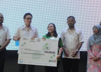 RIZAL NAINY (dua dari kiri) menyampaikan replika cek kepada salah seorang usahawan pada Program Pengukuhan Ekonomi Madani Wilayah Selatan di Hotel Holiday villa, Johor Bahru.