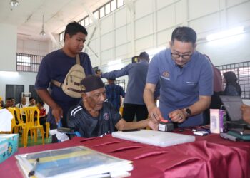 YUSOFF Said bersama cucunya, Muhammad Ammar Hazmi mengambil peluang memperbaharui kad pengenalan sewaktu Program Mekar dan Hari Pendaftaran Negara (HPN) di Dewan Pulau Aman, Batu Kawan, Pulau Pinang semalam. - Pic: IQBAL HAMDAN