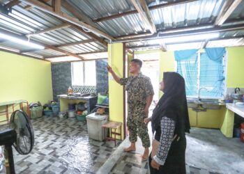 Mohd. Yahya Mohd. Amin menunjukkan rumah Norizan Talib yang 
baru dibaiki di bawah Program Jiwa Murni Kementerian Pertahanan 
di Jalan Kapar, Klang. – UTUSAN/AFIQ RAZALI