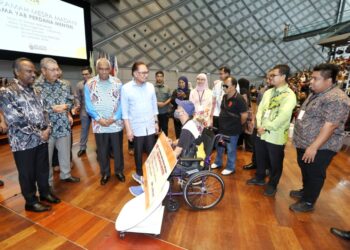 ANWAR Ibrahim (tengah) menyampaikan sumbangan kepada peserta eKasih pada Majlis Ramah Mesra Madani di UTP, Tronoh di Batu Gajah. - UTUSAN/MUHAMAD NAZREEN SYAH MUSTHAFA