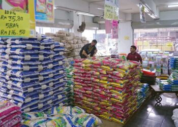 Pekerja menyusun kampit beras import di kedai borong, Jalan Chow Kit, di Kuala Lumpur, baru-baru ini. – MINGGUAN/FAUZI BAHARUDIN