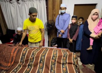 AHLI keluarga menziarahi jenazah Allahyarham Harun Jusoh yang meninggal dunia di rumahnya di Lorong Haji Da, Batu Buruk, Kuala Terengganu, hari ini. - UTUSAN/TENGKU DANISH BAHRI TENGKU TUSOF