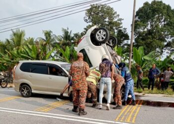 ANGGOTA bomba membantu mengeluarkan mangsa tersepit yang terbabit nahas di Jalan Parit 7, Sungai Manik di Teluk Intan. - UTUSAN/IHSAN JBPM