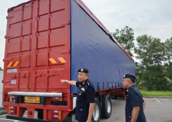 RAHMAT menunjukkan bahagian ekor treler yang dicat warna merah bagi mengaburi pihak berkuasa.