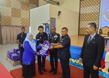 KAMARUL ZAMAN MAMAT (dua dari kanan) menyampaikan beras sumbangan Yayasan Sultan Ibrahim Johor kepada seorang penerima di IPK Johor, Johor Bahru.