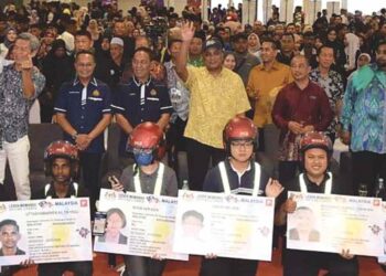 Reezal Merican Naina Merican (baju kuning) bergambar dengan penerima MyLesen Memandu B2 di Dewan Dahlia Midtown Perda, Kubang Menerong, Tasek Gelugor, Pulau Pinang baru-baru ini.