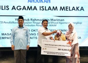 RAHMAD Mariman (tengah) menyampaikan replika cek kepada seorang penerima pada Majlis Jom Mengeteh Dengan Abang Beca di sebuah hotel di Banda Hilir, Melaka.