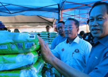 AHMAD Maslan menunjukkan beras yang dijual pada harga jualan Rahmah sempena program Kita Madani Peringkat Negeri Johor di Dataran Majlis Perbandaran Pontian, Pontian, hari ini.