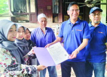 HILMA Yasarah (kiri) dan Hilma Yasirah Hussain menerima surat tawaran melanjutkan pengajian ke Universiti Sains Malaysia daripada Prof. Abdul Rahman Mohamed di rumah mereka di Kampung Nelayan, Teluk Kumbar, Pulau Pinang semalam.