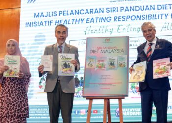 MUHAMMAD Radzi Abu Hassan ketika melancarkan Siri Panduan Diet Malaysia dan Inisiatif Healthy Eating Responsibility for Women (HER) di Putrajaya. - UTUSAN/KAMARIAH KHALIDI