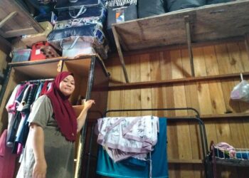 ROHAYA Wan Abdullah menunjukkan pakaian dan dokumen penting disimpan di tempat tinggi sebagai persiapan menghadapi banjir di Kampung Tersang, Rantau Panjang, Kelantan. – UTUSAN/ROHANA ISMAIL