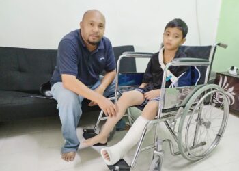 MOHAMAD HILMI Bahari bersama anaknya yang berkerusi roda di Taman Bandar Baru, Masjid Tanah, Alor Gajah, Melaka. - UTUSAN/AMRAN MULUP