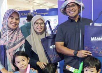 Awatif Adilah Atan (berdiri, kiri) bersama ahli keluarganya ketika mengunjungi sebuah gerai pameran MSAM di Setia Fontaines, Bertam, Kepala Batas.