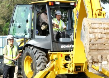 NGA Kor Ming mengendali jengkaut ketika merasmikan majlis pecah tanah projek pembinaan pasar sementara Pasir Pinji di Ipoh hari ini. - UTUSAN/MUHAMAD NAZREEN SYAH MUSTHAFA