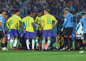 PEMAIN Brazil dan Uruguay mengerumuni Neymar yang terbaring menahan sakit dalam aksi kelayakan Piala Dunia 2026 di Stadium Centenario, Montevideo kelmarin. – AFP