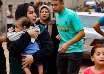 Seorang wanita yang cedera  mendukung bayinya untuk menyelamatkan diri dalam siri pengeboman Israel di Rafah, selatan Semenanjung Gaza  semalam. Foto AFP