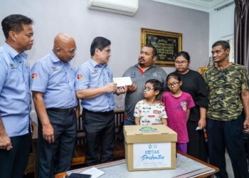 JOHN Riba Marin (tiga dari kiri) menyampaikan pencen penakat Allayarhamah Nor Azlina Jaafar yang meninggal dunia pada 17 Oktober lalu akibat jangkitan kuman pada hati kepada suami, Muhammad Basir Abu Bakar yang turut ditemani anak-anak di kediaman mereka di Taman Setia 2, Balakong di sini, hari ini. -UTUSAN/ MUHAMAD IQBAL ROSLI