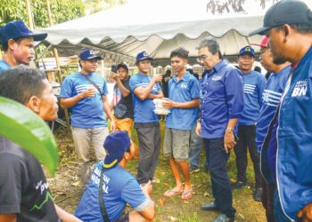 JOHARI Abdul Ghani beramah mesra dengan masyarakat Orang Asli semasa berkempen di Kampung Sungai 
Bot, Pelangai, Bentong, semalam. – UTUSAN/SHAIKH AHMAD RAZIF