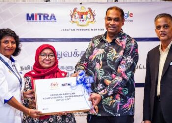 R. RAMANAN menyerahkan komputer riba kepada Guru Besar SJKT Kajang, S. Bijealachemy (kiri) sebagai gimik sekolah pertama menerima komputer riba di SJKT Kajang, hari ini. Turut menyaksikan, Ketua Pengarah Unit Transformasi Masyarakat India Malaysia (Mitra), N. Raveendran (kanan). - UTUSAN/MUHAMAD IQBAL ROSLI