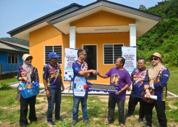 MUHAMMAD Faiz Fadzil (tiga dari kiri) menyampaikan replika kunci kepada Mohd. Sapian Hussin (tiga dari kanan) yang menerima rumah baharu di Pulau Redang, Kuala Nerus, hari ini. -UTUSAN/PUQTRA HAIRRY ROSLI