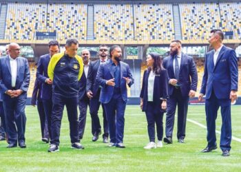 TUNKU Ismail Sultan Ibrahim (empat, kanan) dan Hannah Yeoh (tiga, kanan) melihat permukaan padang Stadium Nasional, Bukit Jalil yang baru ditukar dengan rumput Zeon Zoysia semalam. Turut sama, Hamidin Mohd. Amin (dua, kiri). – UTUSAN/SHIDDIEQIIN ZON