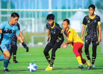 AKSI pemain Sekolah Sukan Bukit Jalil (jersi kuning, merah) ketika menentang  AMD Future di Gambang, Pahang semalam. – IHSAN NFDP