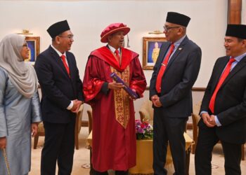 MAZLAN Abd Ghaffar (dua, kanan) beramah mesra bersama Abdullah Sulaiman (tengah) yang menerima PhD pada Majlis Konvokesyen UMT Kali Ke-21, Kuala Nerus, hari ini. - UTUSAN/PUQTRA HAIRRY ROSLI