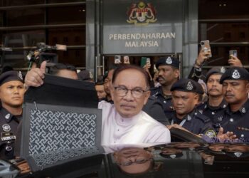 Anwar Ibrahim menunjukkan beg  menyimpan dokumen Belanjawan 2024 sebelum dibentangkan di Parlimen semalam. – utusan/FAISOL MUSTAFA