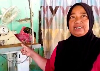 RAMLAH Abdullah menunjukkan mesin jahit yang digunakan untuk mencari rezeki yang turut tenggelam dalam banjir di Kampung Bendang Padang, Kupang di Baling, semalam.