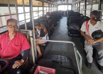 BAHARUDDIN Bani membawa tiga penumpang ke Kampar dari bandar di Teluk Intan. – UTUSAN/AIN SAFRE BIDIN