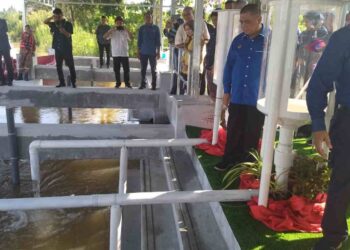 SAARANI Mohamad (kanan) menyaksikan pelepasan benih ikan ke Sungai Perak di Jeti Nelayan Darat Kampung Luat, Lenggong semalam.