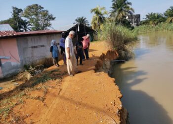 PENDUDUK menunjukkan keadaan tebing sungai yang terhakis yang terletak berhampiran rumah penduduk di  Kampung Simpang Tiga, Batu 9 Jalan Changkat Jong di Teluk Intan. -UTUSAN/AIN SAFRE BIDIN