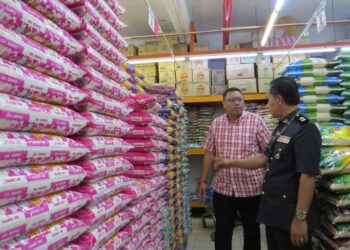 MOHD. Syahbuddin Hashim (kiri) dan Mohd. Koma Shapii (kanan) meninjau bekalan beras di sebuah pasaraya di Bandar Gua Musang, Kelantan. - UTUSAN/AIMUNI TUAN LAH