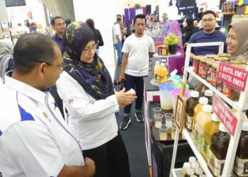 ROZIAH (kanan) mendengar penerangan daripada pengusaha produk tempatan yang terlibat dalam program Mini Karnival Barangan Malaysia 2023 Zon Selatan yang diadakan di pusat beli belah Paradigm Mall, Johor Bahru, hari ini.