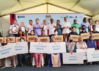 V. Sivakumar bersama penerima Perkeso dan bantuan pada program Jelajah Madani Bersama Menteri Sumber Manusia di Pasaraya Mydin Pulau Sebang, Alor Gajah, Melaka. - UTUSAN/AMRAN MULUP