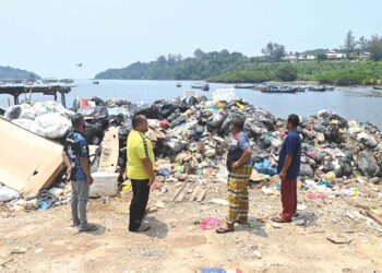 PENDUDUK kampung melihat sebahagian daripada longgokan sampah di Pulau Redang, Kuala Nerus. 
– UTUSAN/PUQTRA HAIRRY ROSLI