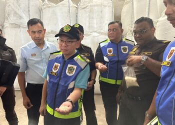 CHAN Foong Hin menunjukkan sampel beras putih yang diperiksa di salah sebuah kilang sempena Op BPT di Alor Setar.