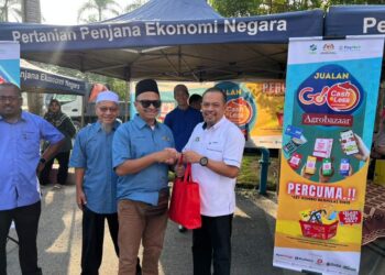 HAIRUDDIN Yunos (kanan) pada Majlis Pelancaran Program Go Cashless@ABR di ABR Pasar Mini Esah Haniff, Umbai, Merlimau, Melaka. - UTUSAN/AMRAN MULUP